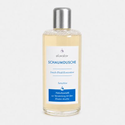 Bottle of Elixator Schaumsdusche shower gel with lace-like top and pale yellow liquid, label shows product name and 'Dusch-Flid Konzentrat' text.